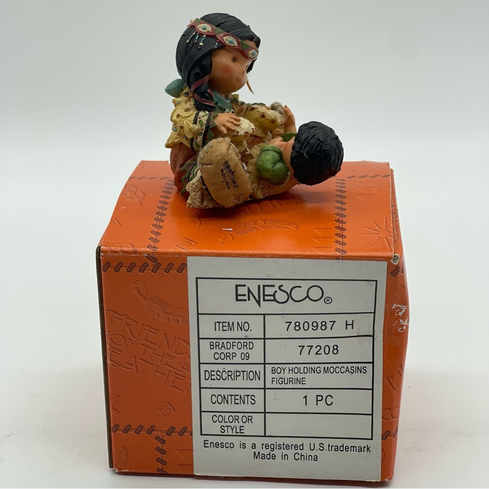 Friends of the Feather Boy Holding Moccasins